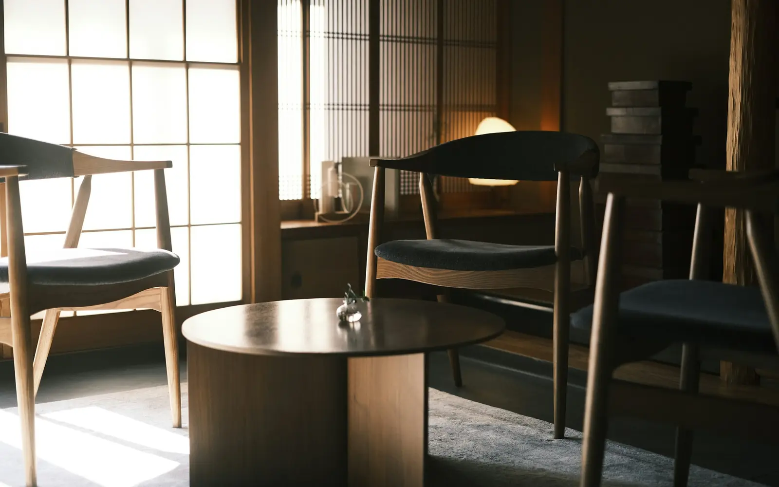 Quiet café interior with wooden chairs, a round table and soft window light