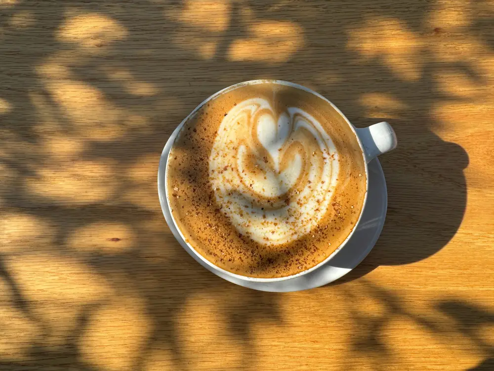 Flat white with heart-shaped latte art on a wooden table