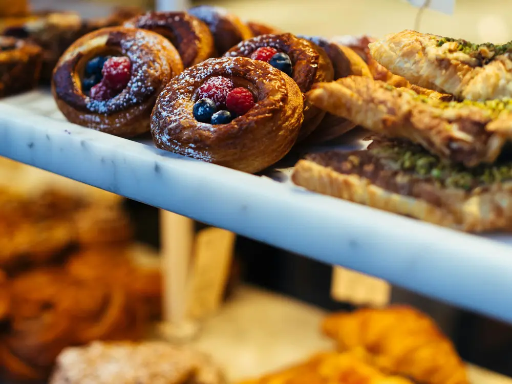 Glass counter filled with croissants and fruit pastries